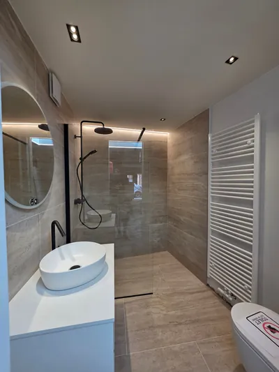 Badkamer met inbouwspots en indirecte verlichting bij de douche